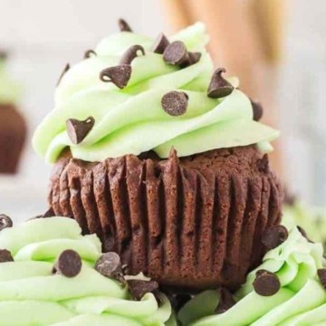 A stack of chocolate cupcakes with green frosting.