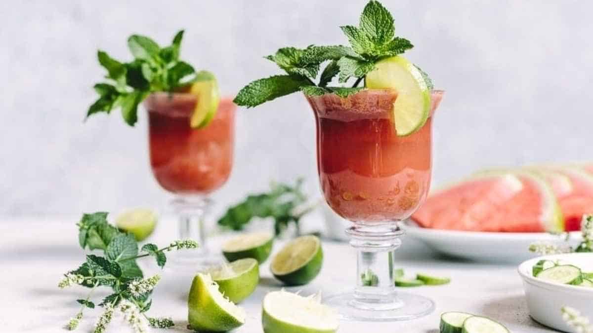 Two glasses of watermelon bloody mary with limes and mint.