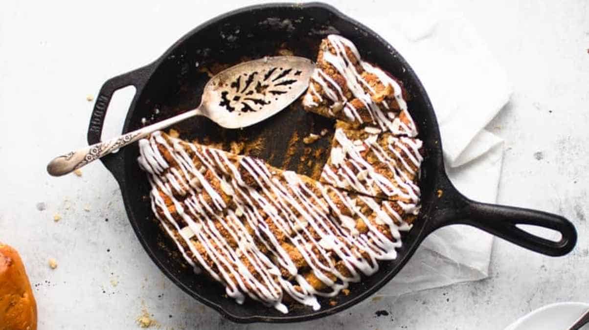 French toast with a drizzle of icing on a cast-iron skillet.