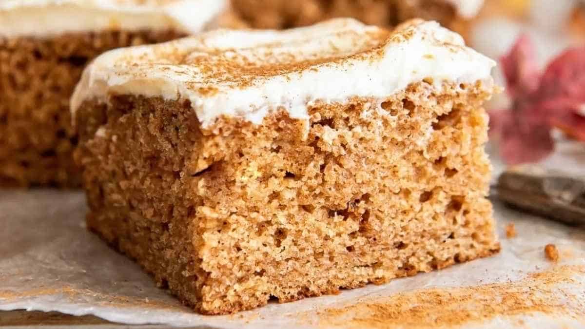 A slice of pumpkin cake with icing on top.