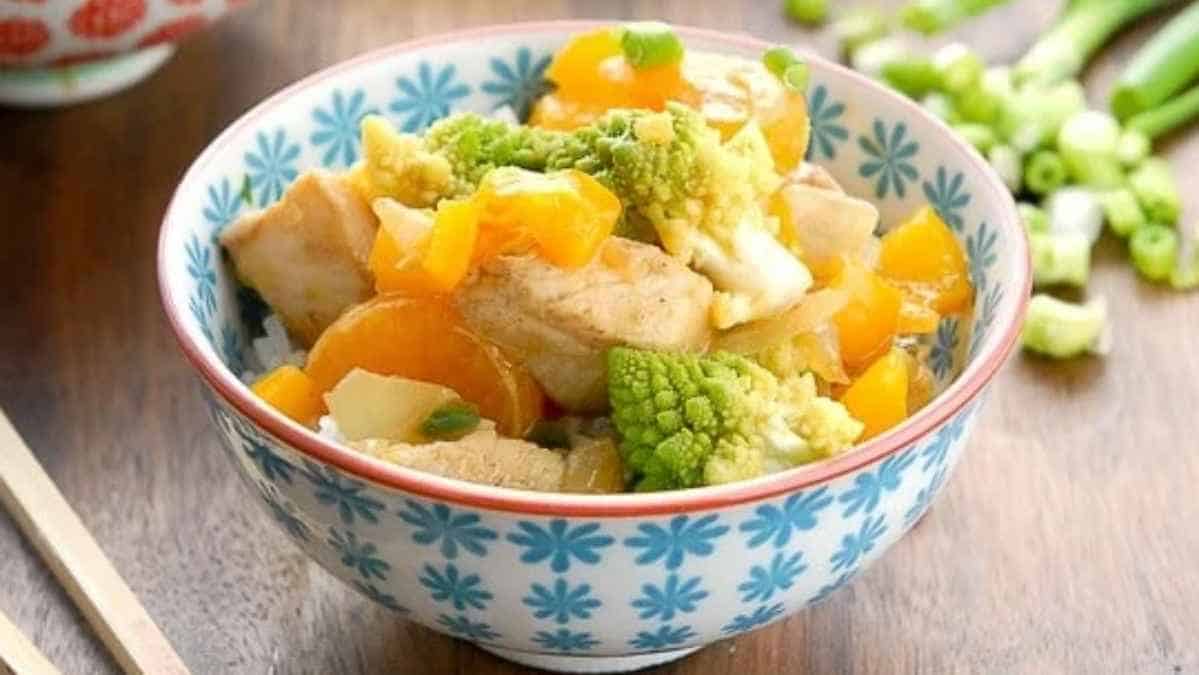 A bowl of stir-fried tofu with broccoli and bell peppers.