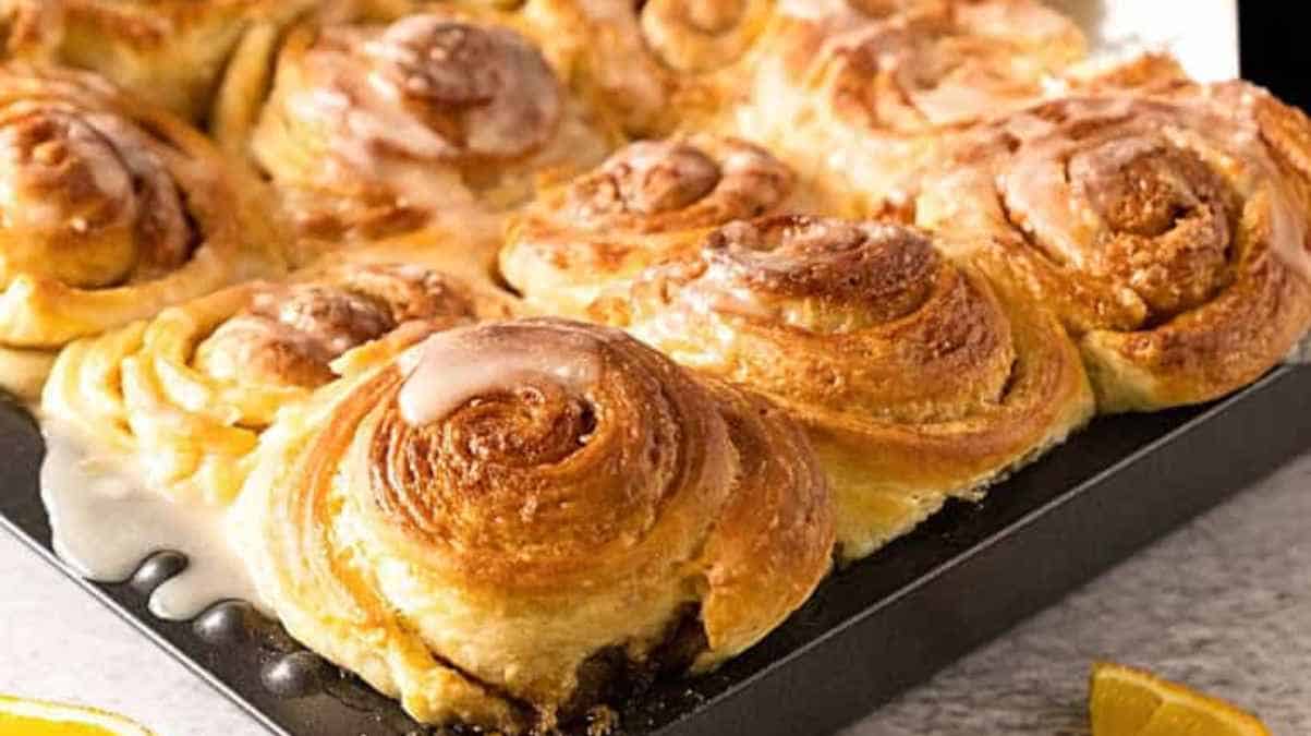 A tray of freshly baked cinnamon rolls with icing.