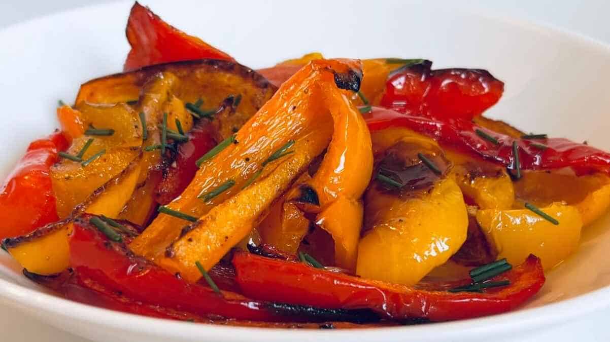 Roasted peppers in a white bowl with thyme.