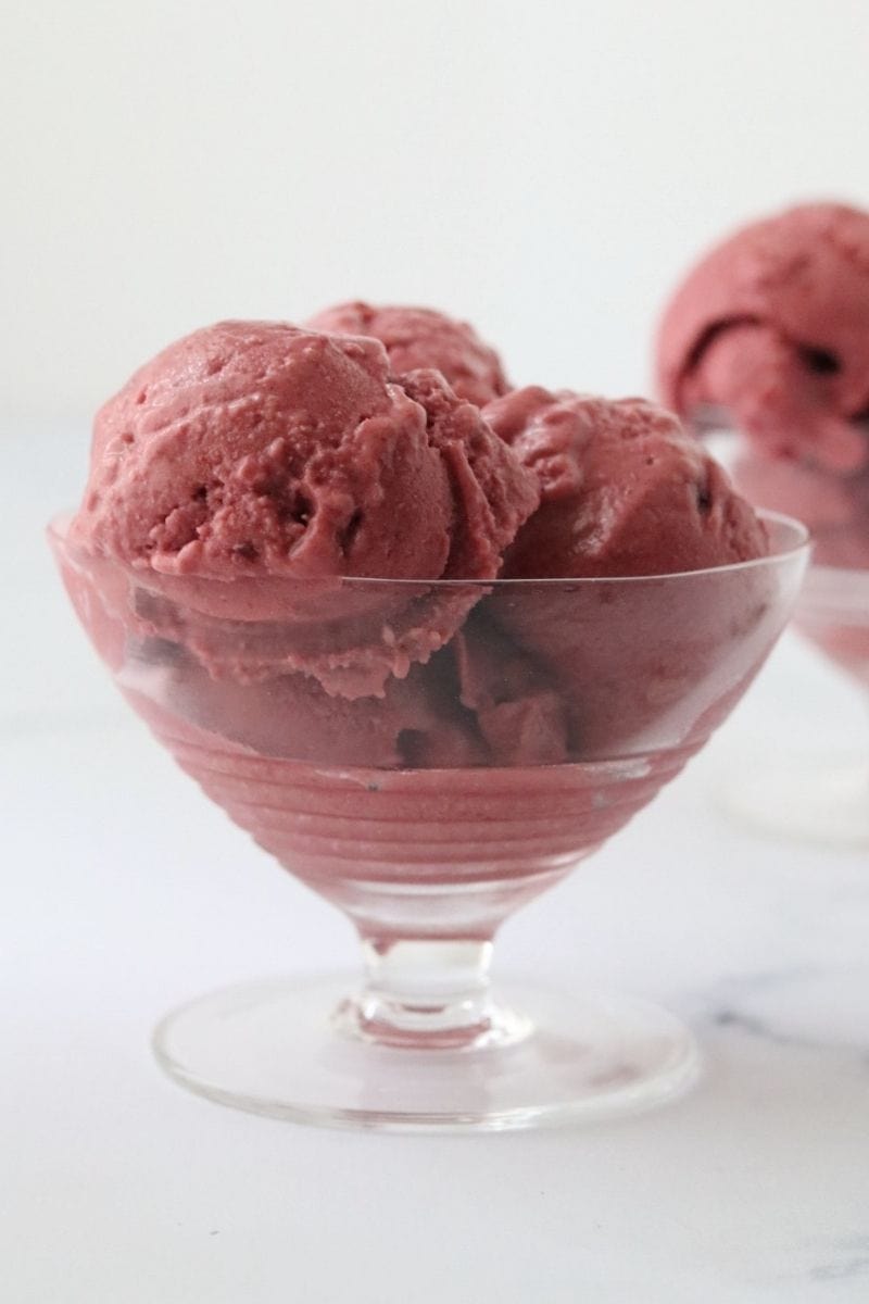 a glass filled with red velvet ice cream and a second one in the background.
