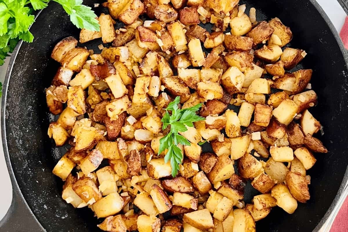 Pan-fried diced potatoes garnished with parsley.