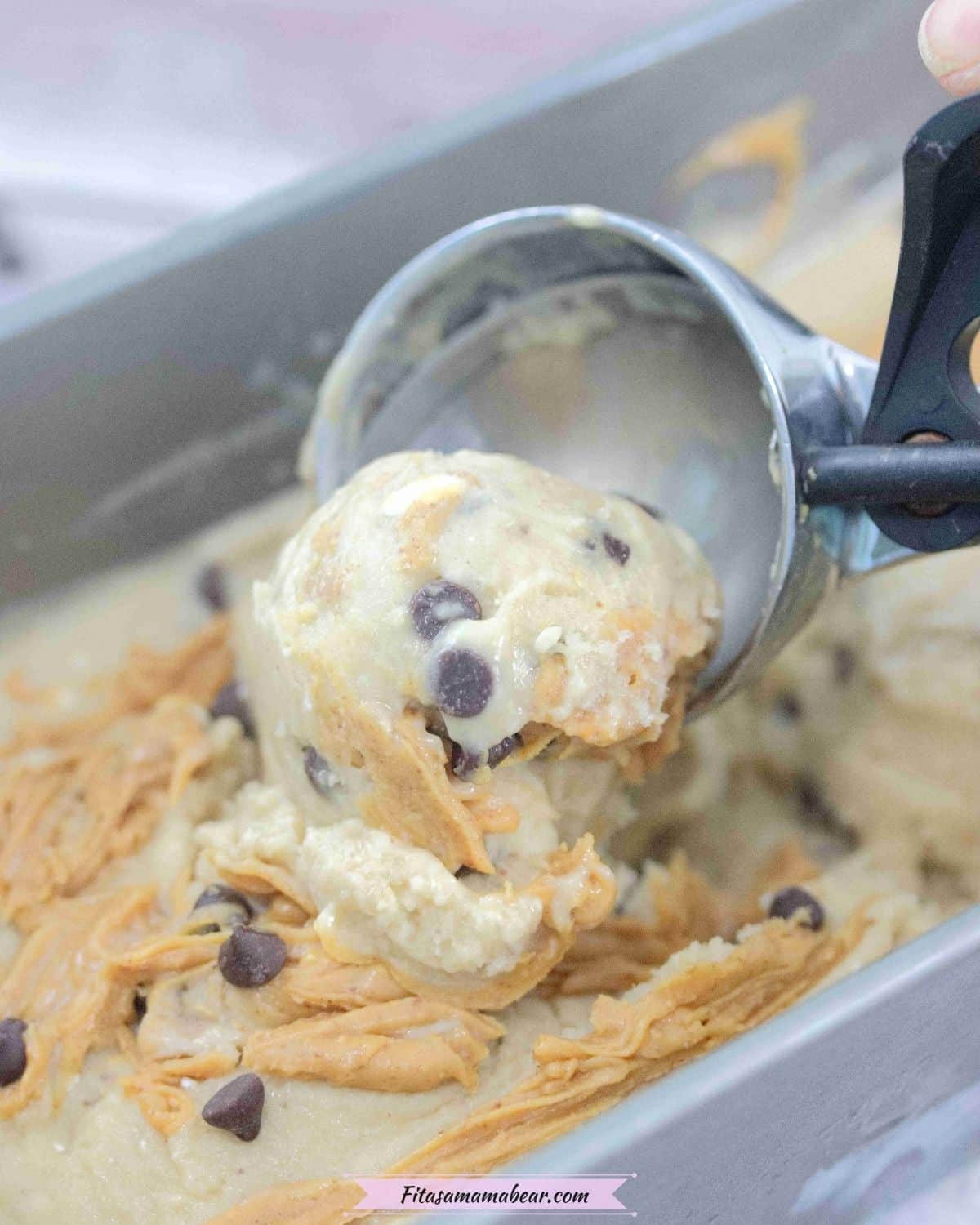 Close up of an ice cream scoop scooping peanut butter chocolate chip ice cream.
