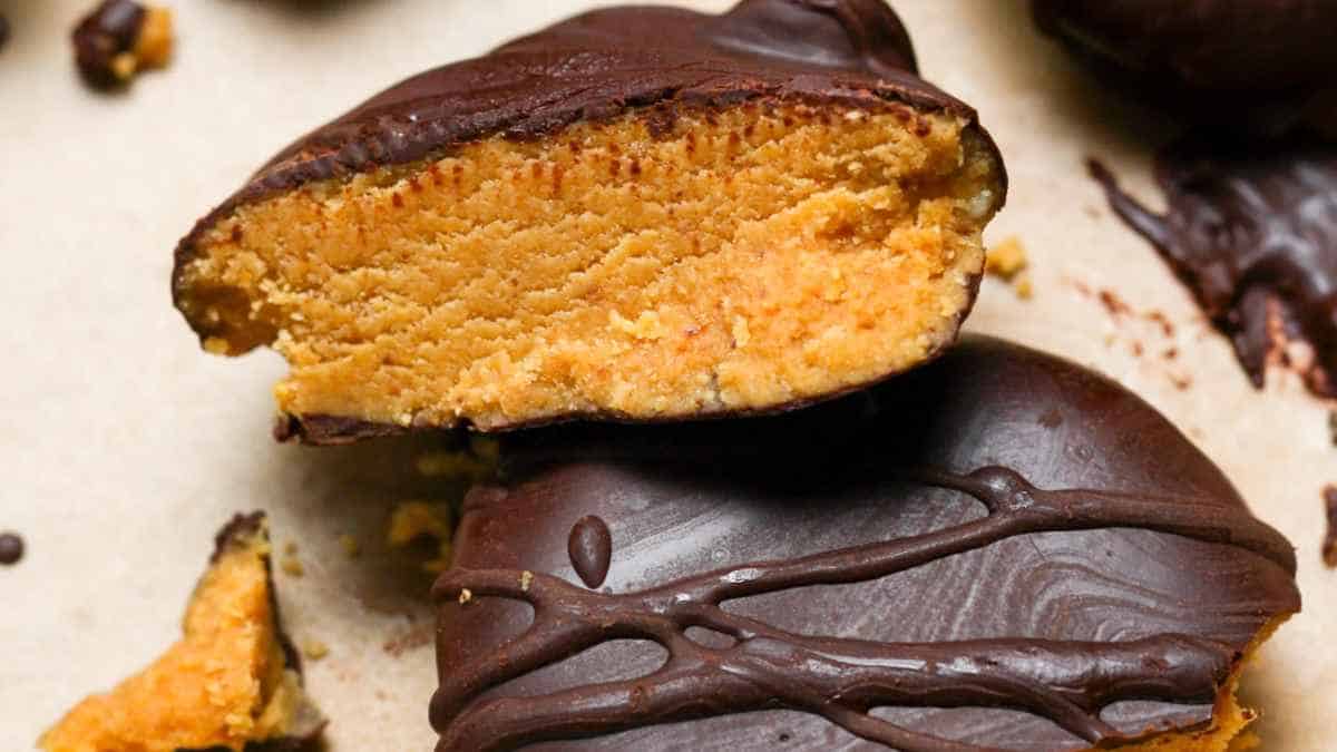 Chocolate-covered peanut butter patties with one halved to show inside texture.