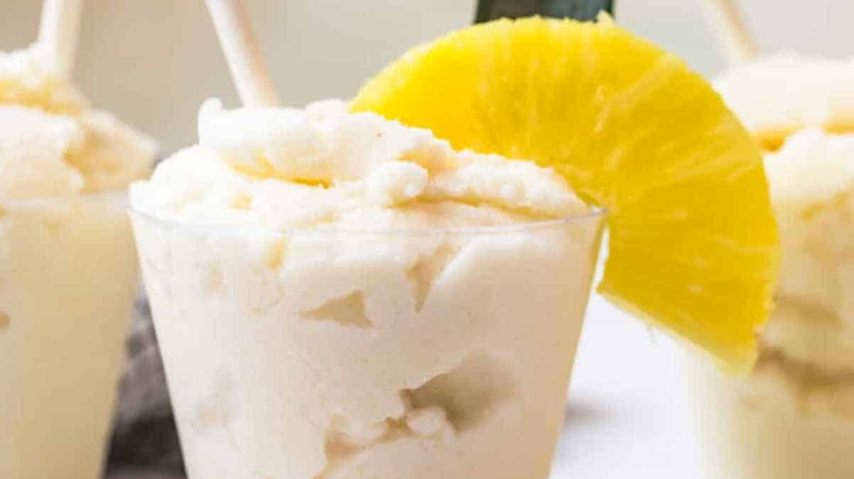 Three cups of pineapple sorbet garnished with pineapple slices.