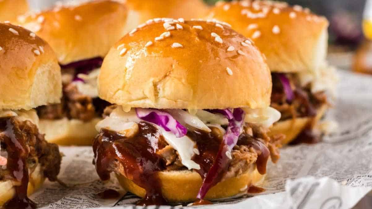 Pulled pork sliders with coleslaw on sesame buns.