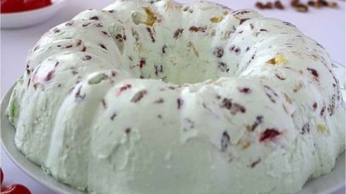 A white bundt cake with cherries on top.
