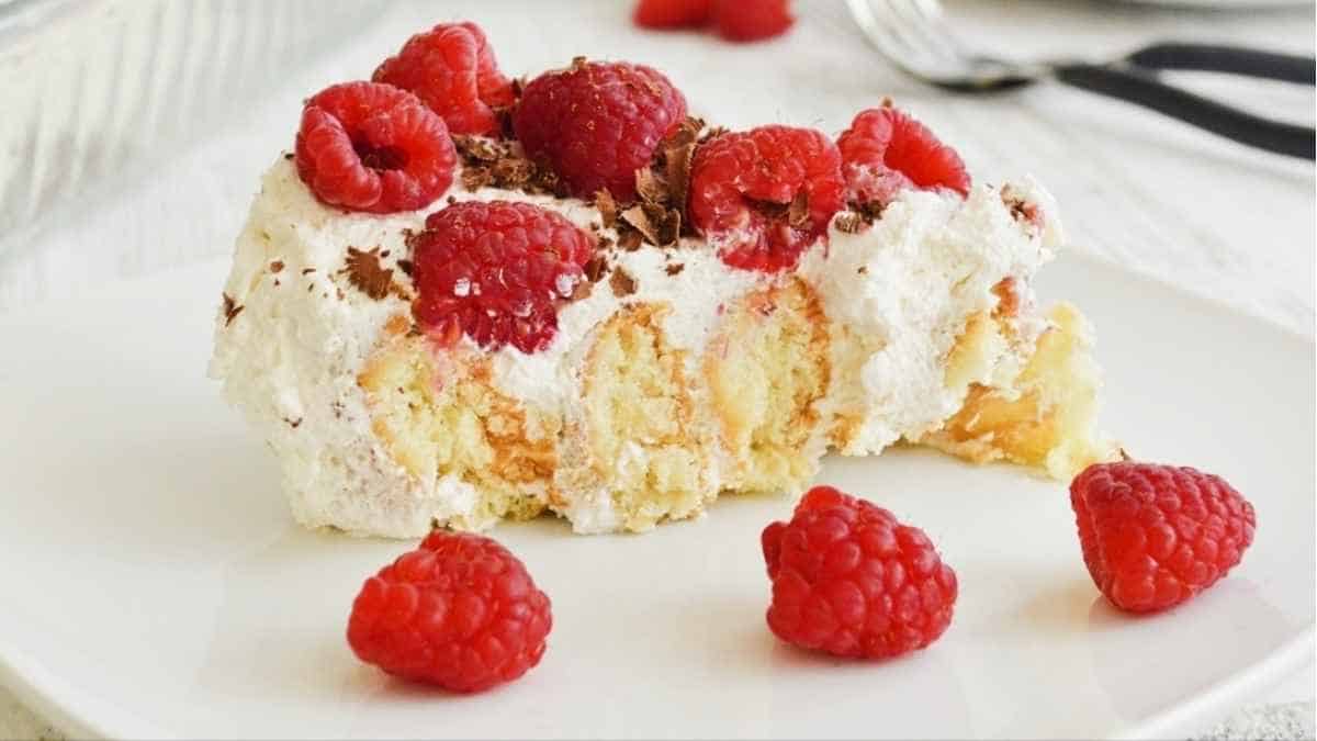 A slice of cake with raspberries on a plate.