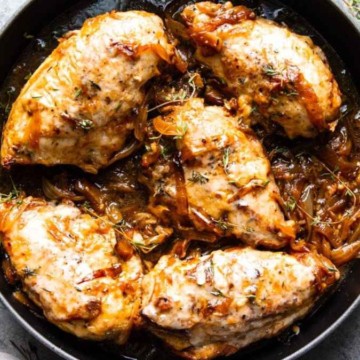 Roasted chicken thighs with herbs in a cast-iron skillet.