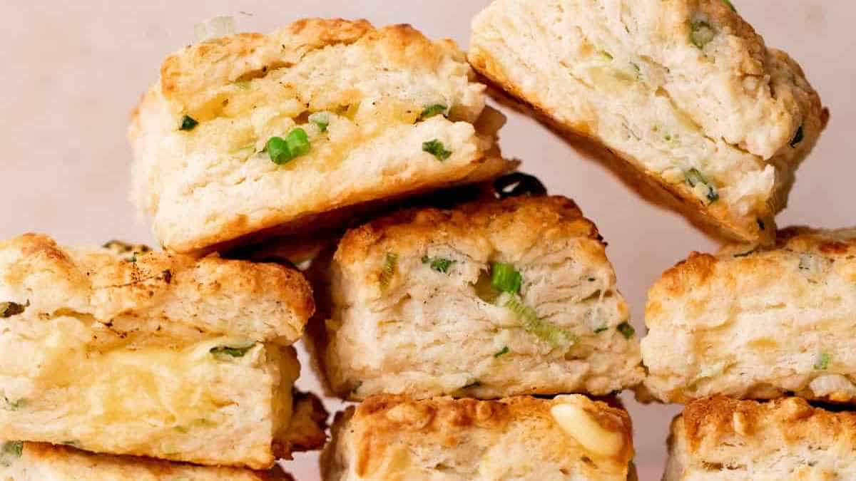 Freshly baked savory scones with herbs and cheese on a light background.