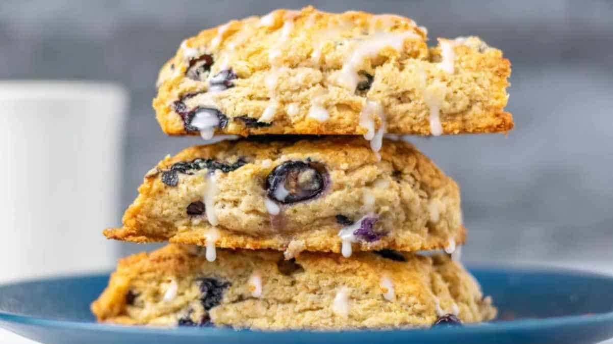 A stack of blueberry scones with glaze on a blue plate.