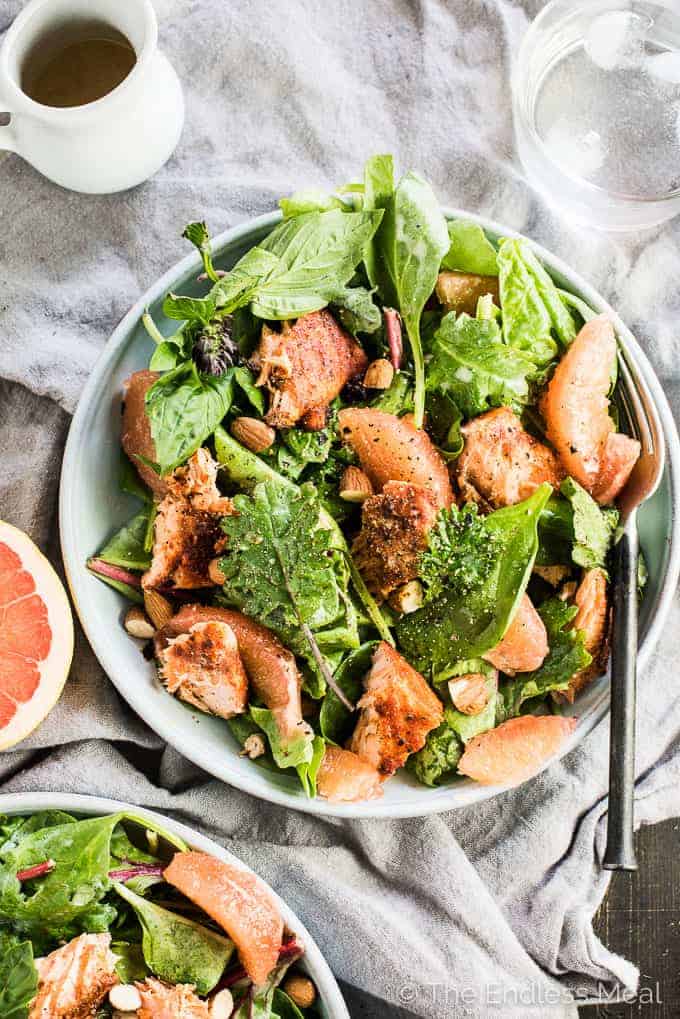 This fresh and tropical Spicy Salmon Salad is as delicious as it gets. Toss your favorite spring greens in a grapefruit coconut salad dressing and top with bites of grapefruit, chopped almonds, a little dill, and spicy grilled salmon. It's a healthy lunch or dinner recipe that is gluten-free + paleo + Whole30 approved. 
