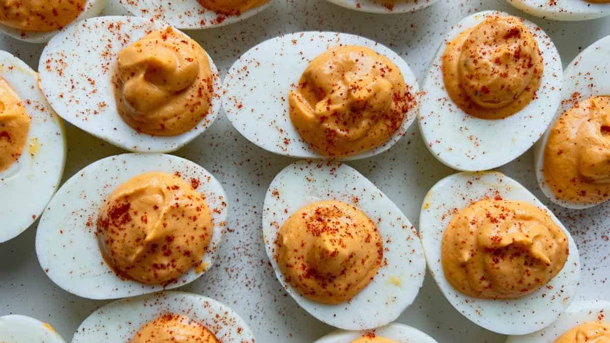 A platter of deviled eggs sprinkled with paprika.