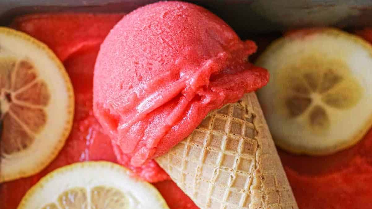 A pink ice cream cone with a lemon wedge.