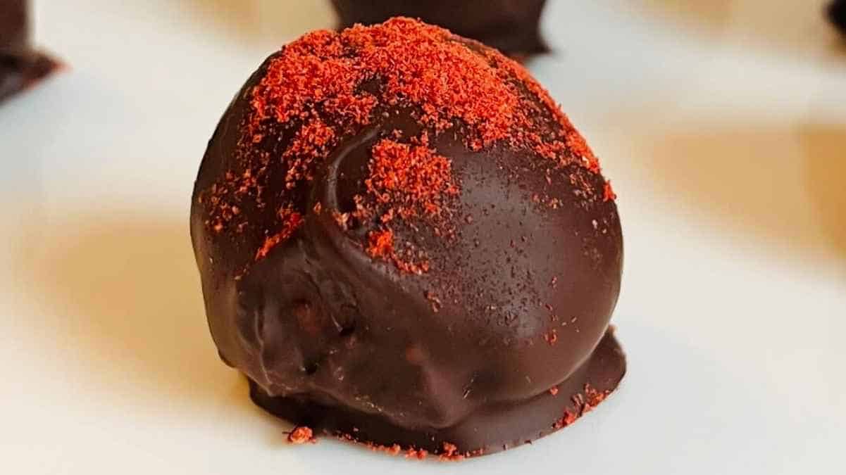 A chocolate ball with red flakes on top.