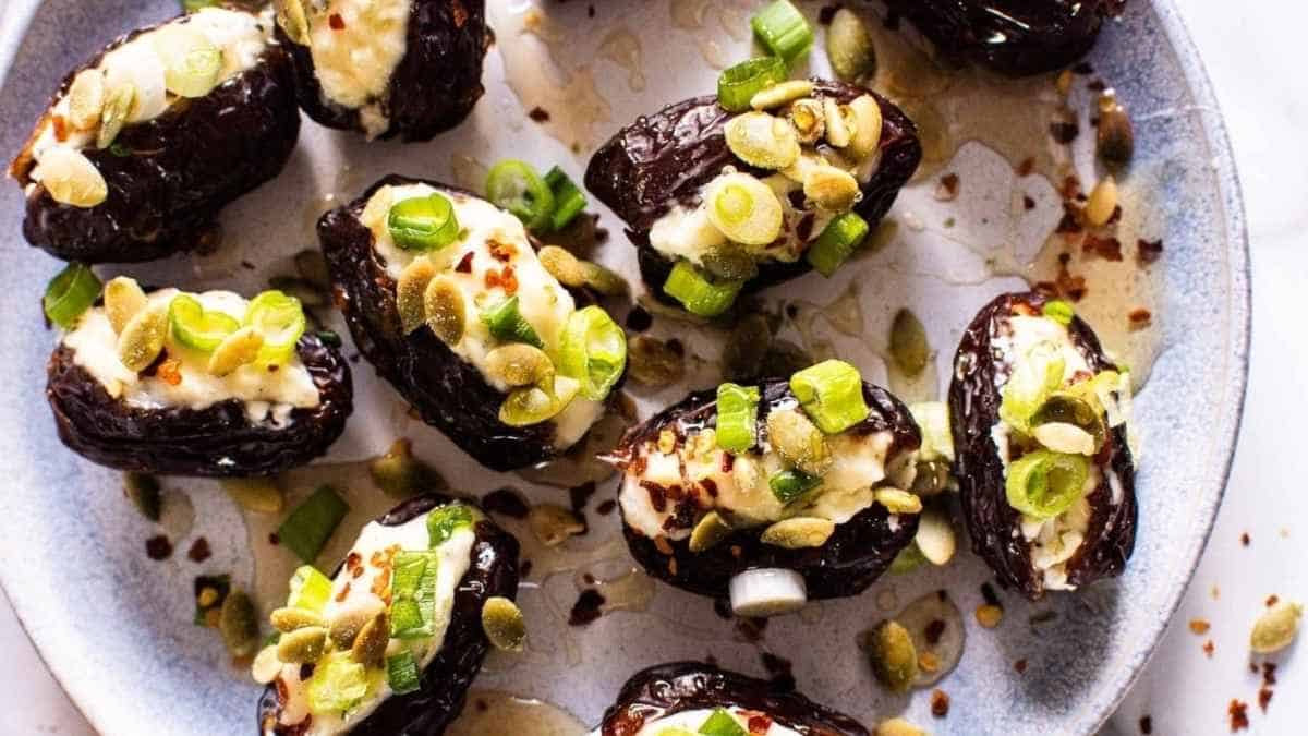 Roasted figs with goat cheese and pomegranate seeds on a plate.