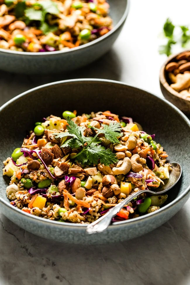 A bowl crunchy Thai quinoa salad in a bowl with a spoon on the side.
