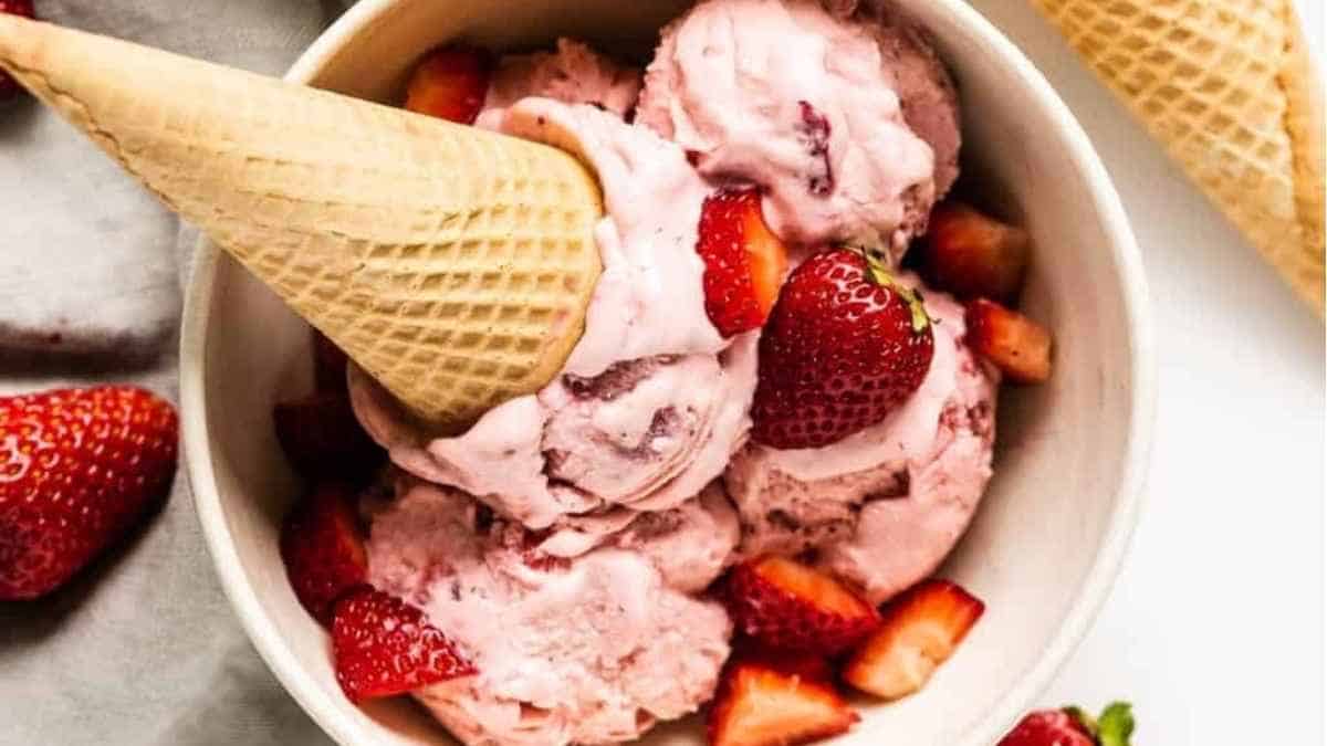 A bowl of ice cream with strawberries.
