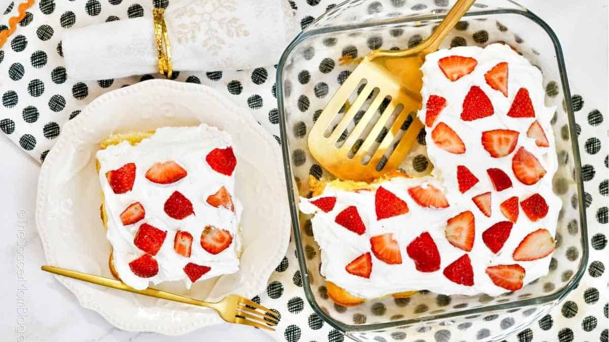 A couple of glass dishes with strawberries and frosting.