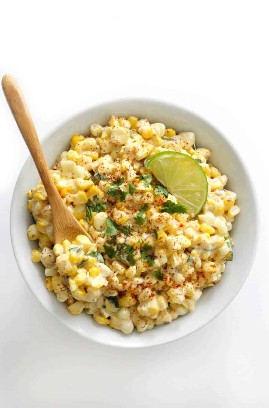 grilled vegan mexican street corn salad with wooden spoon.
