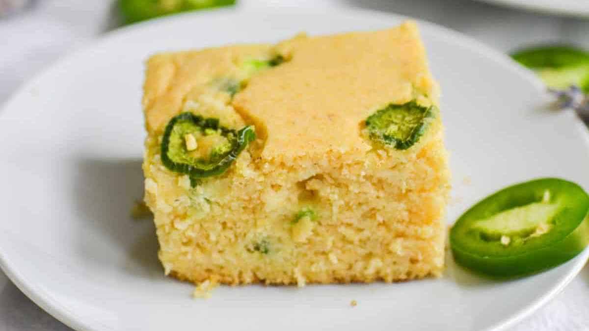 A slice of jalapeño cornbread on a white plate.