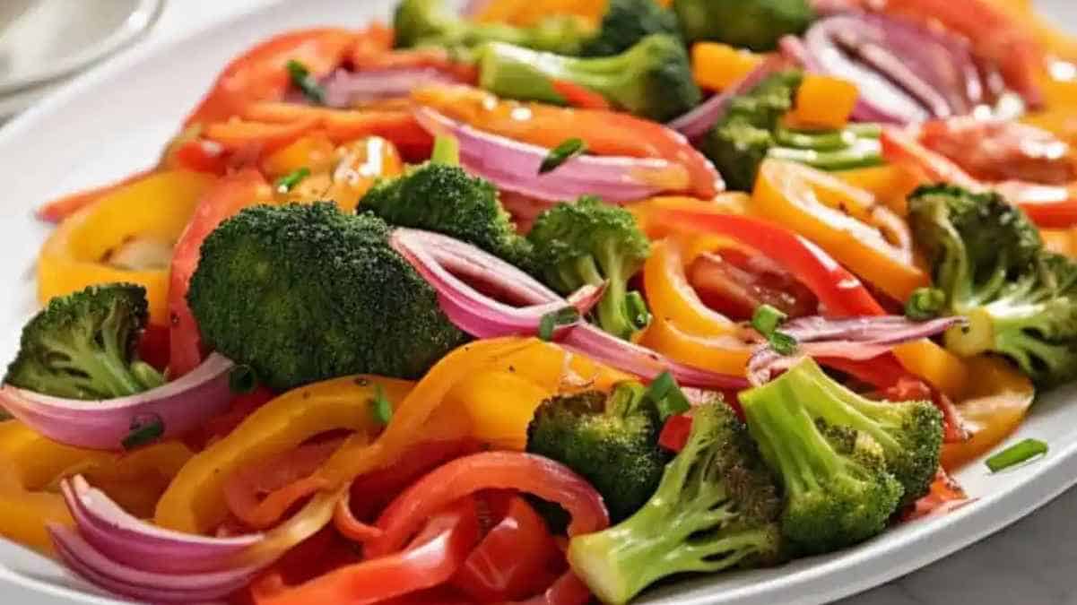 A colorful plate of mixed vegetables including bell peppers, broccoli, and red onions.