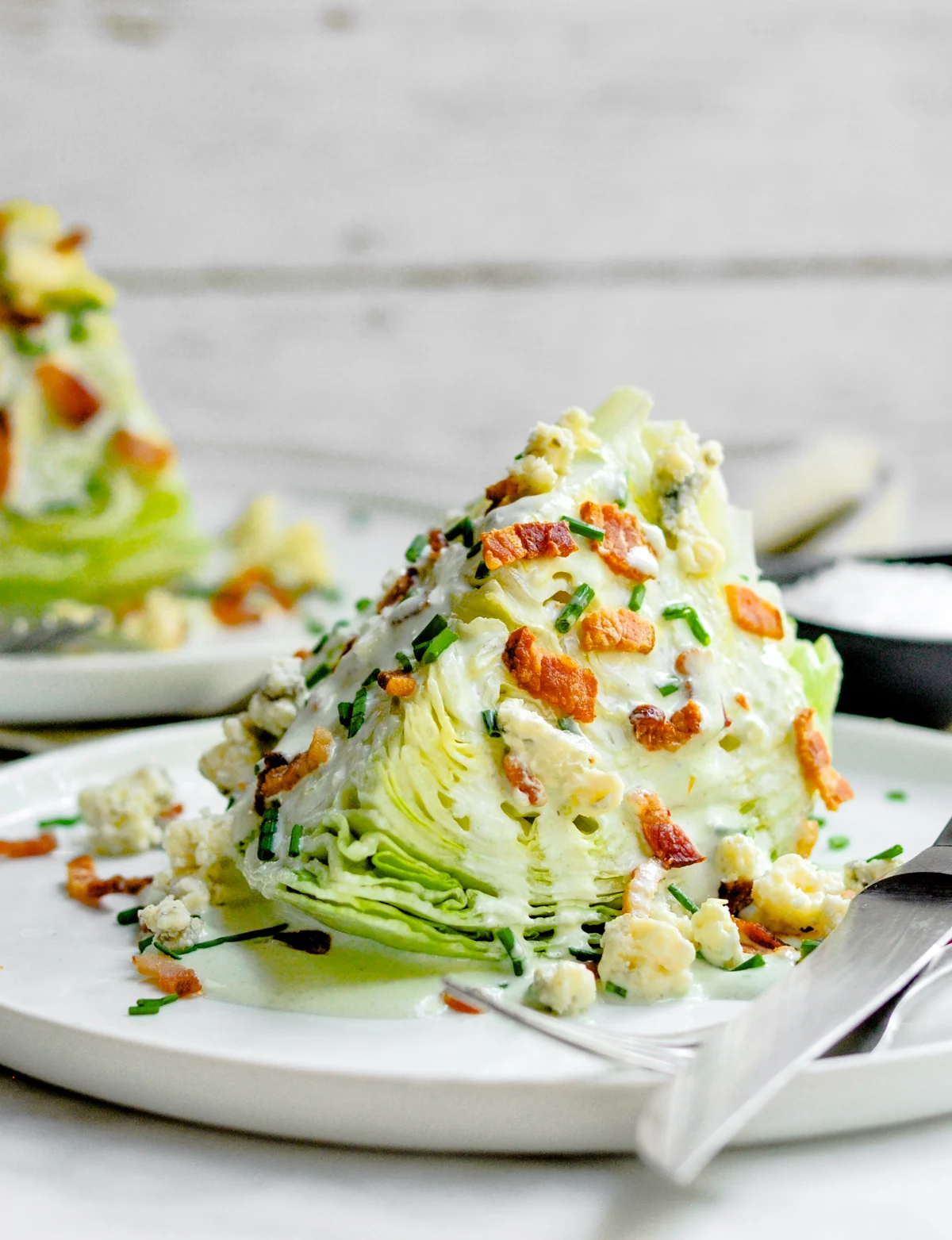 Wedge Salad served on white plates with knife and fork. 