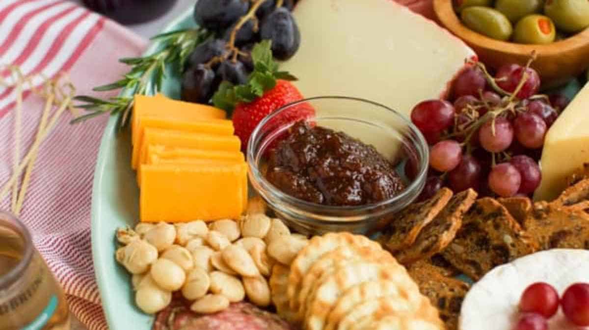 Assorted cheese and fruit platter with crackers and nuts.