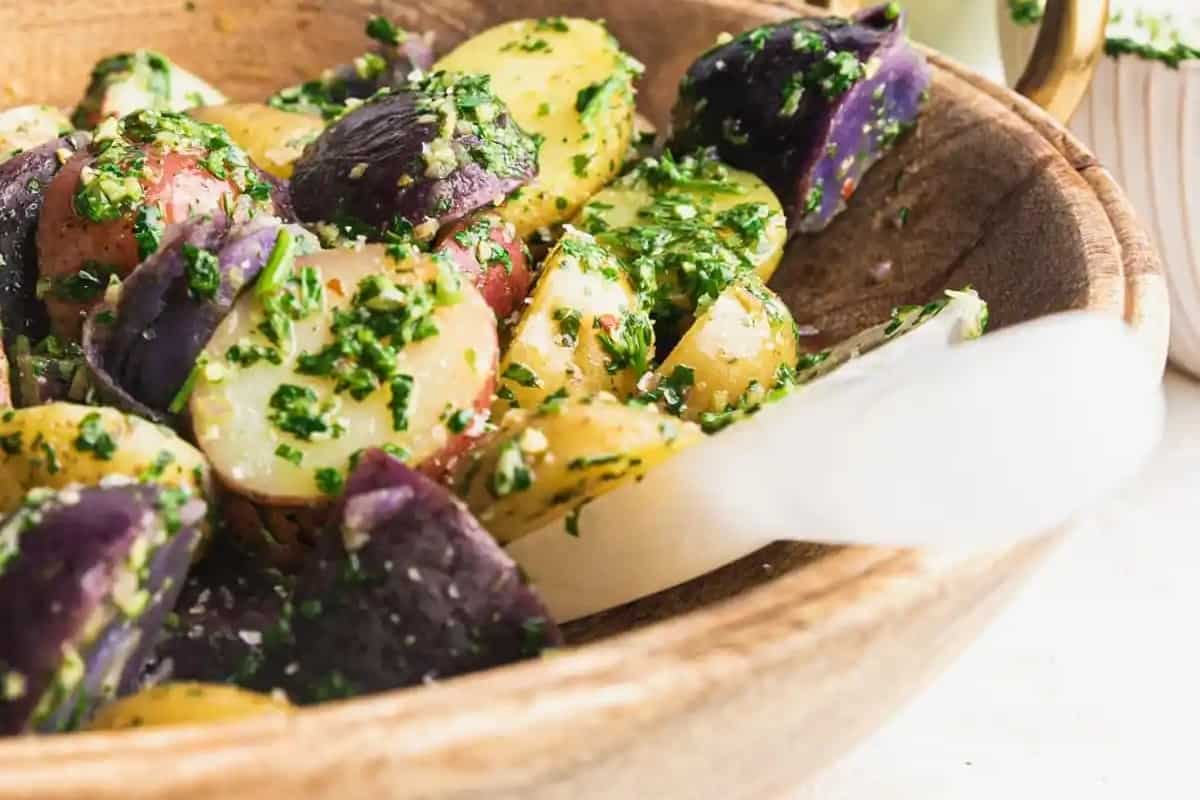 Purple potato salad in a wooden bowl.
