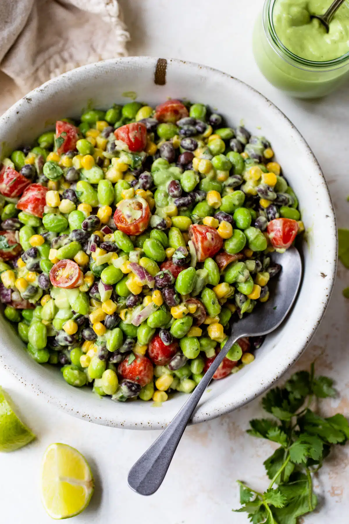 a bowl of edamame salad with a spoon.