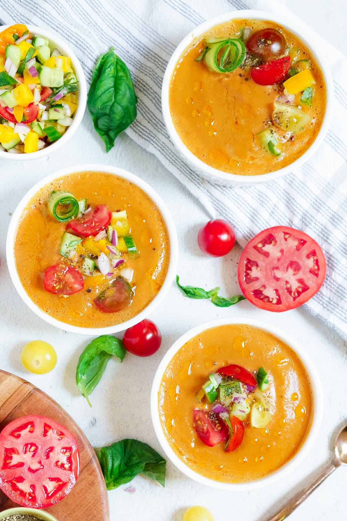 3 bowls of gazpacho soup with a salad.