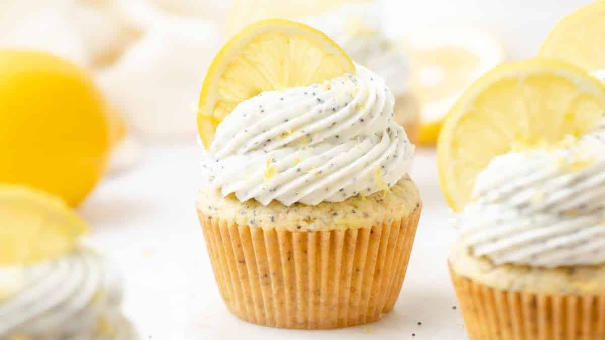 Lemon cupcakes with poppy seed frosting and a slice of lemon garnish.