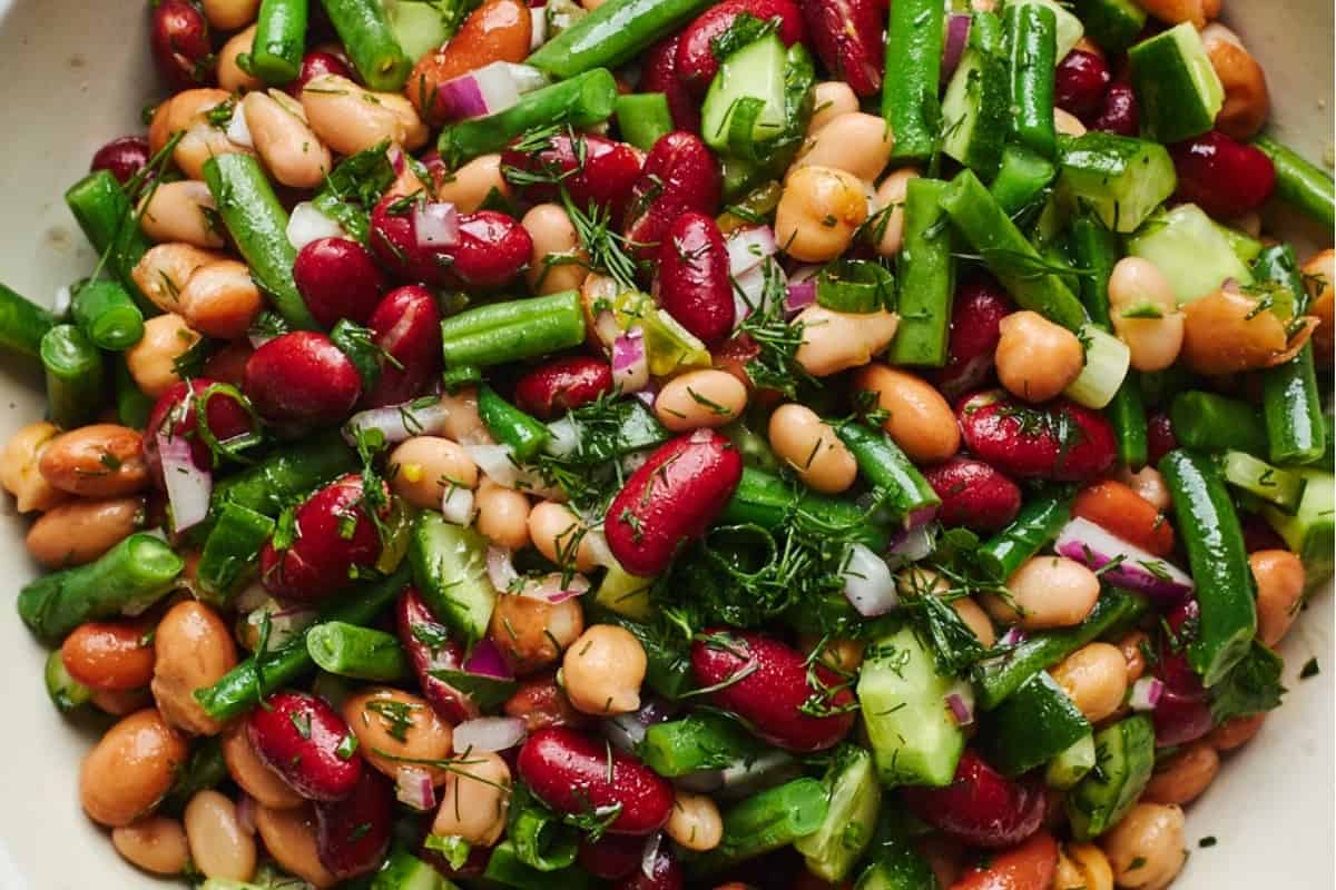 A bowl of bean and bean salad with dill.