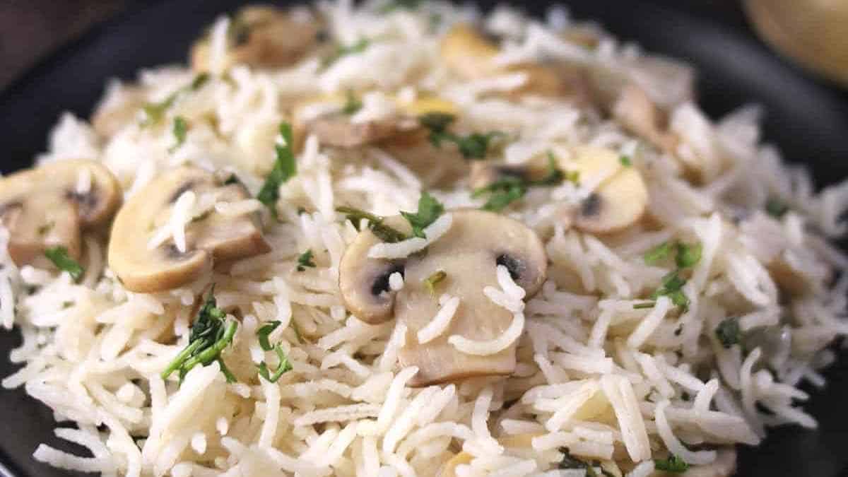 A plate of mushroom rice garnished with herbs.