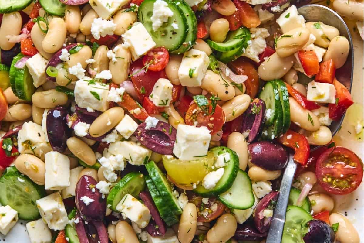 A white bean salad with tomatoes, cucumbers and feta cheese.