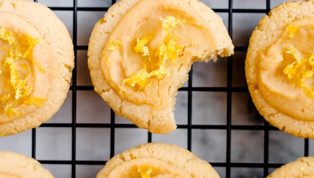 Freshly baked cookies with a zest topping cooling on a wire rack.