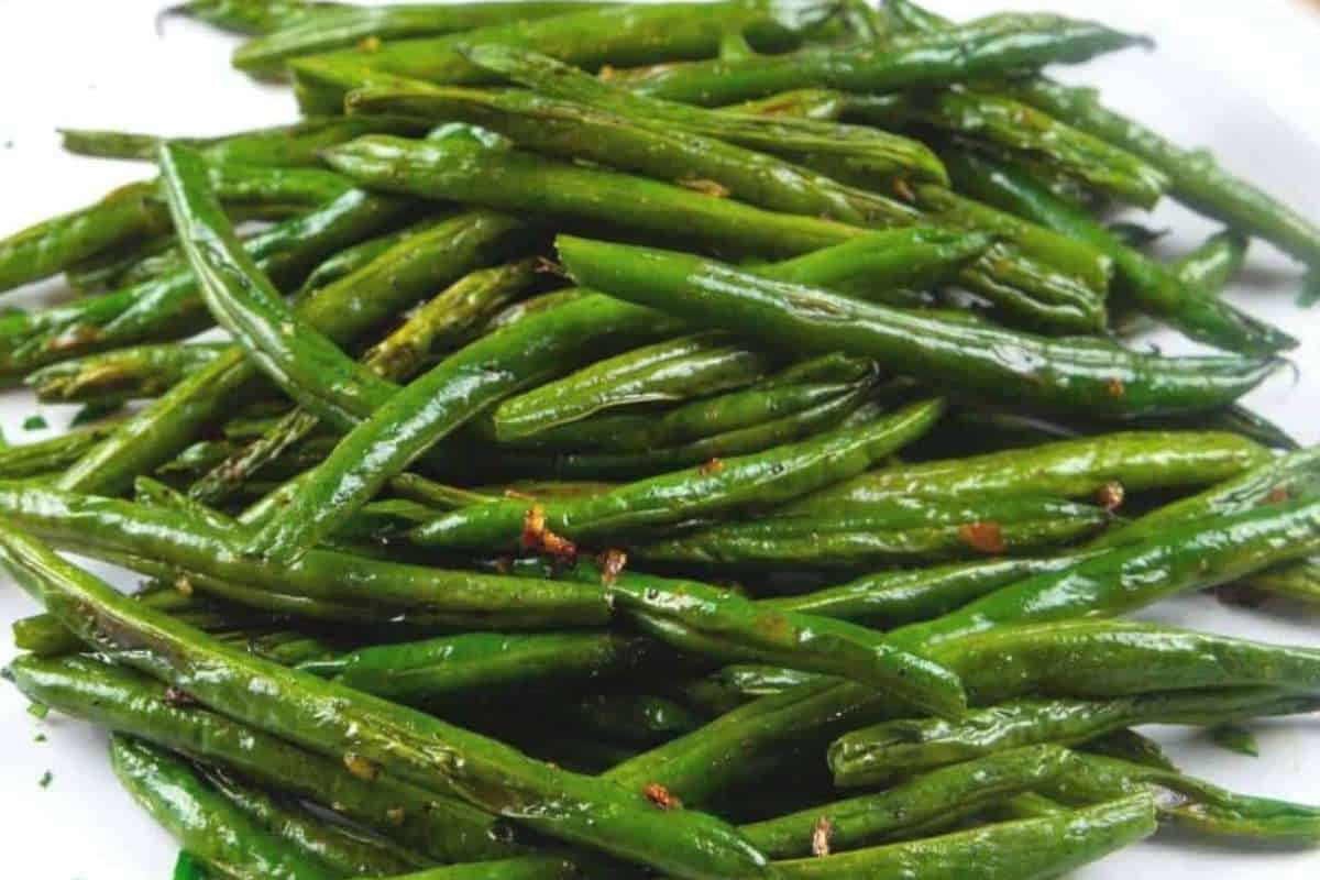 A plate of roasted green beans seasoned with spices.