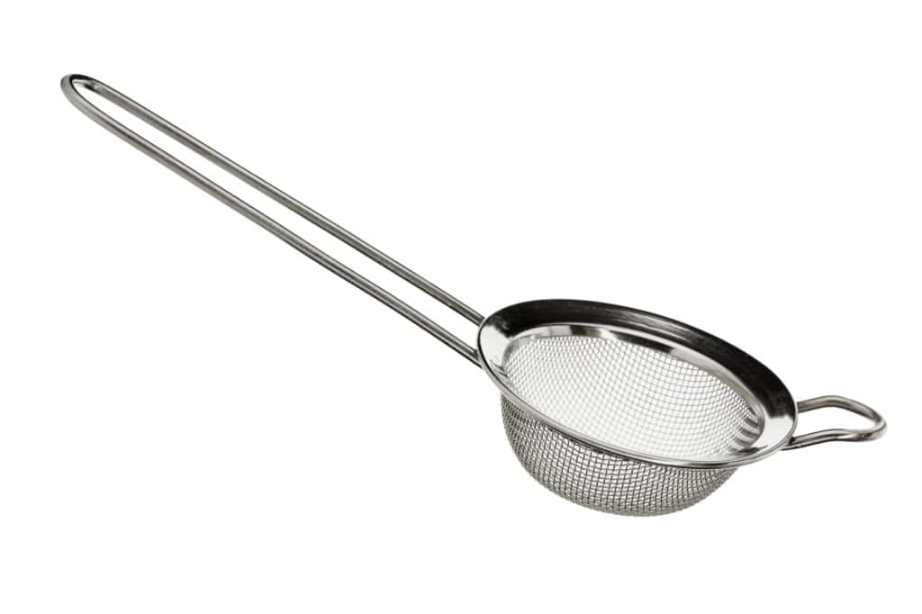 A stainless steel conical fine mesh strainer with a long handle, isolated on a white background.