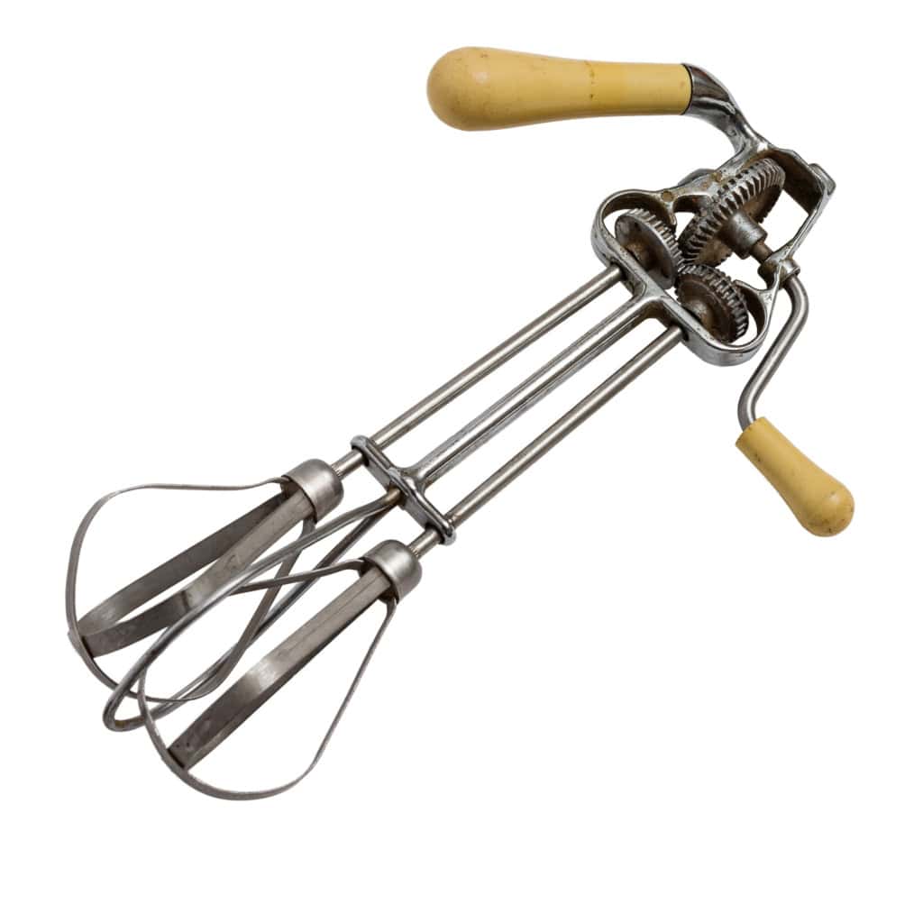 Vintage manual egg beater with metal beaters and wooden handles on a white background.