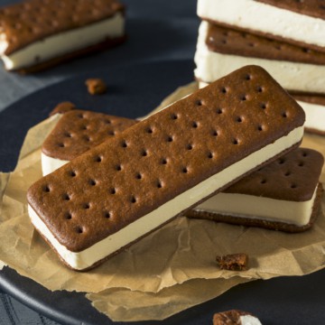 Stack of ice cream sandwiches and igloos on a plate with parchment paper.