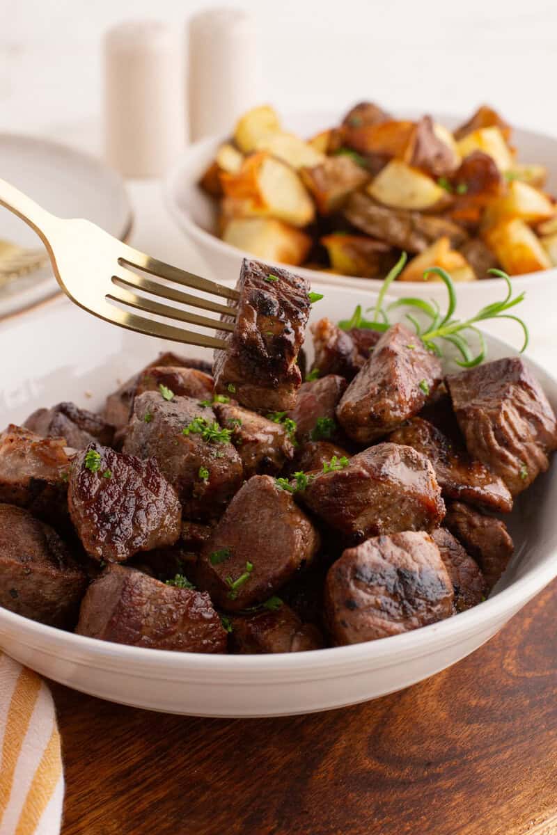 steak tips in a bowl with a fork