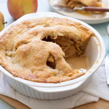 apple pie in pie plate with slice out