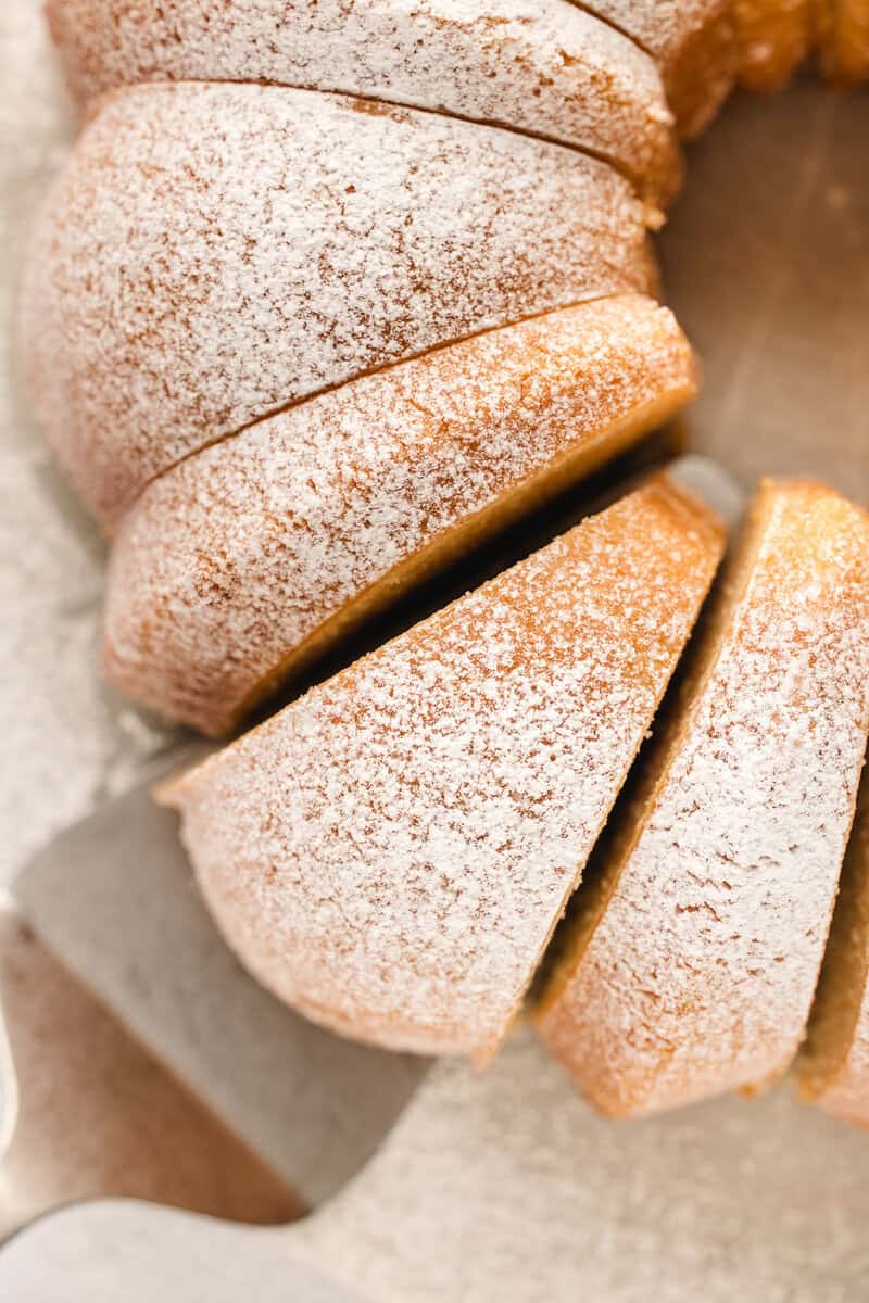 Close-up of a sliced, powdered sugar-dusted Bundt cake.