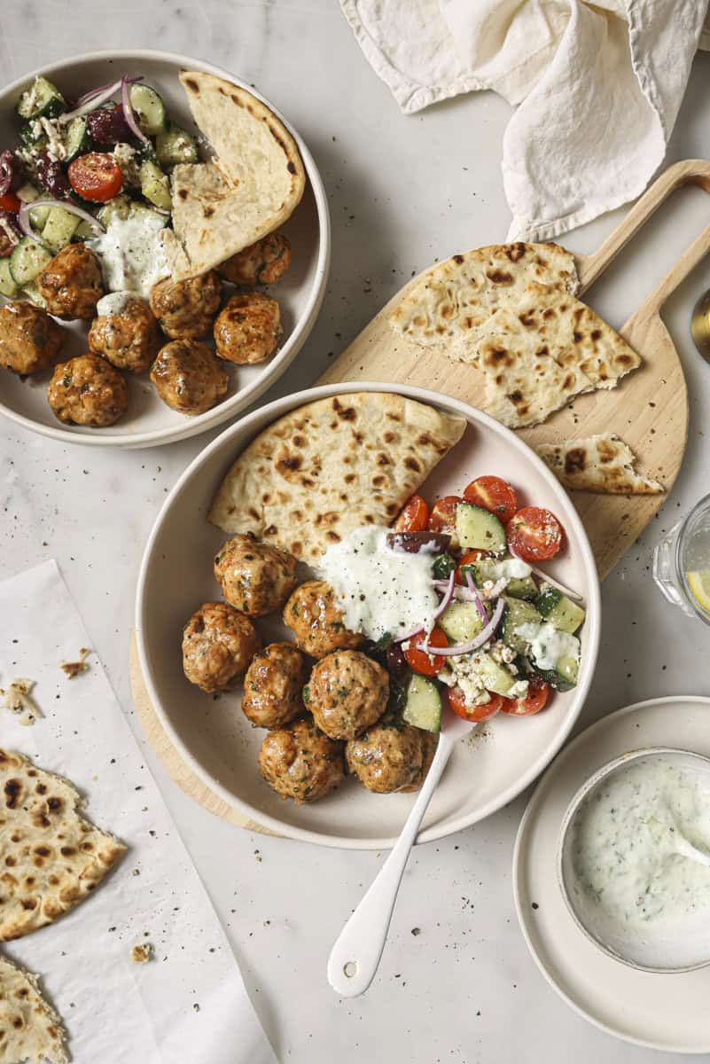 greek chicken meatballs in a bowl with salad
