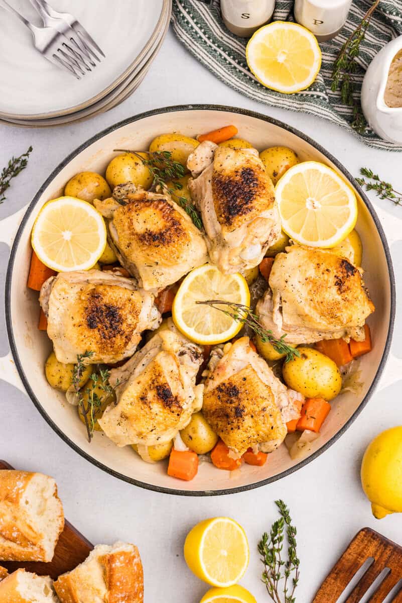 braised chicken in a dutch oven with carrots and potatoes