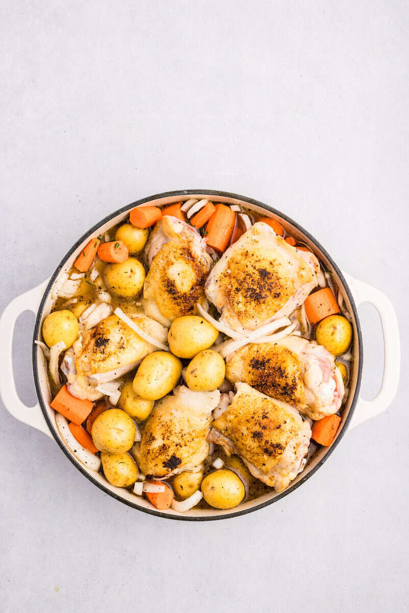 chicken thighs added back to dutch oven with vegetables