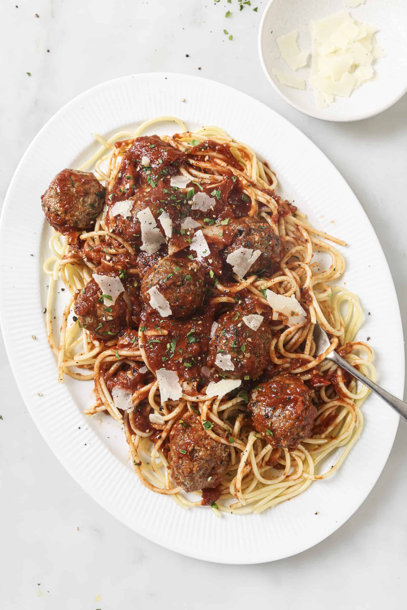 spaghetti and meatballs on a white platter